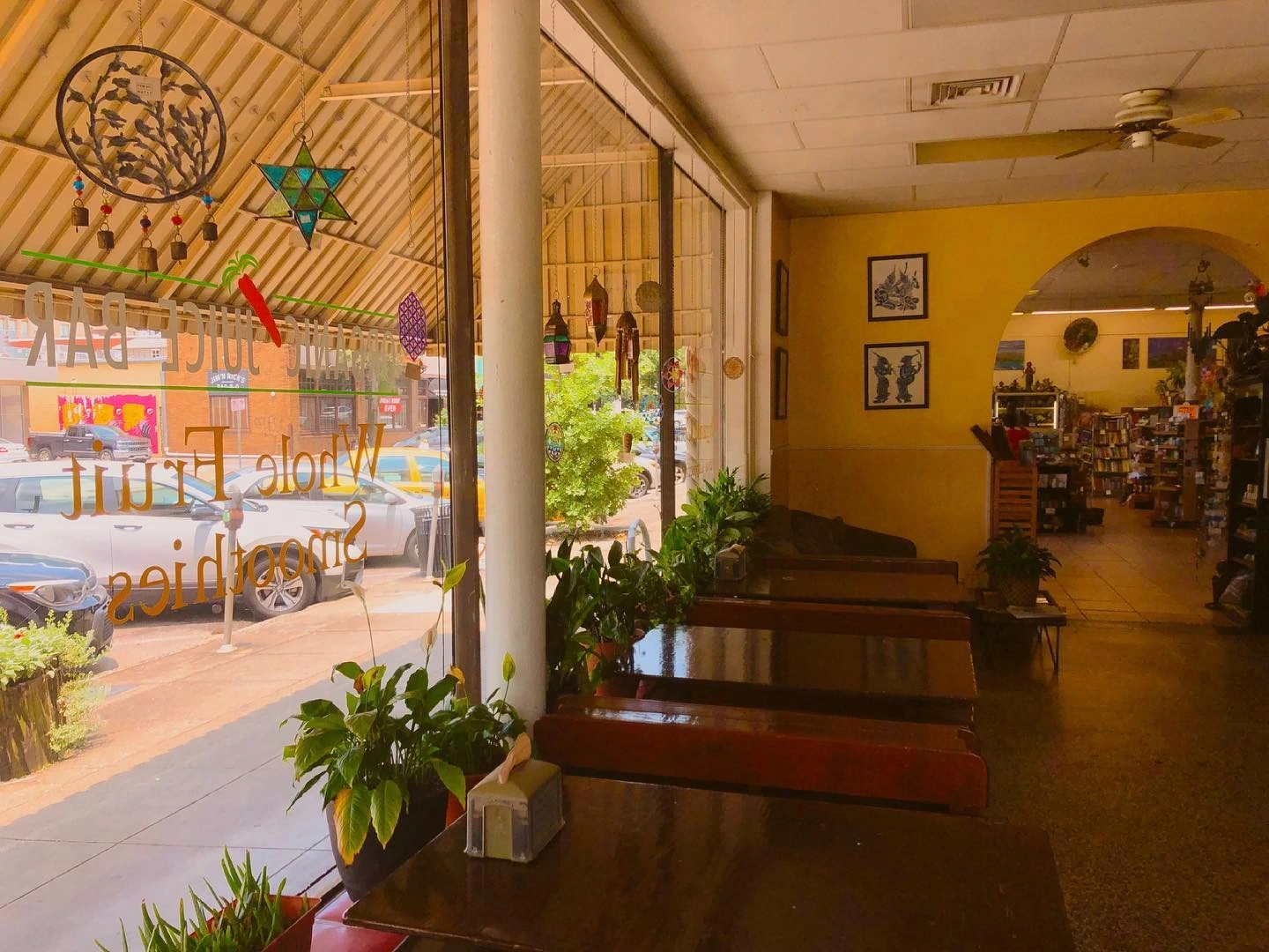 Interior of a cafe with wooden benches, looking out a large glass window